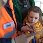 A volunteer registring Ukrainian refugees at train station.